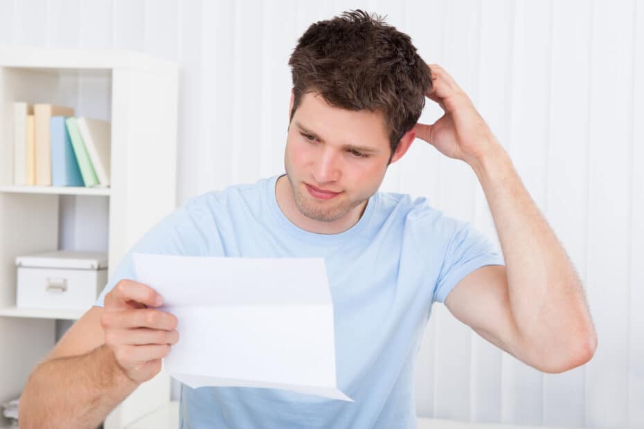Confused man looking at paper